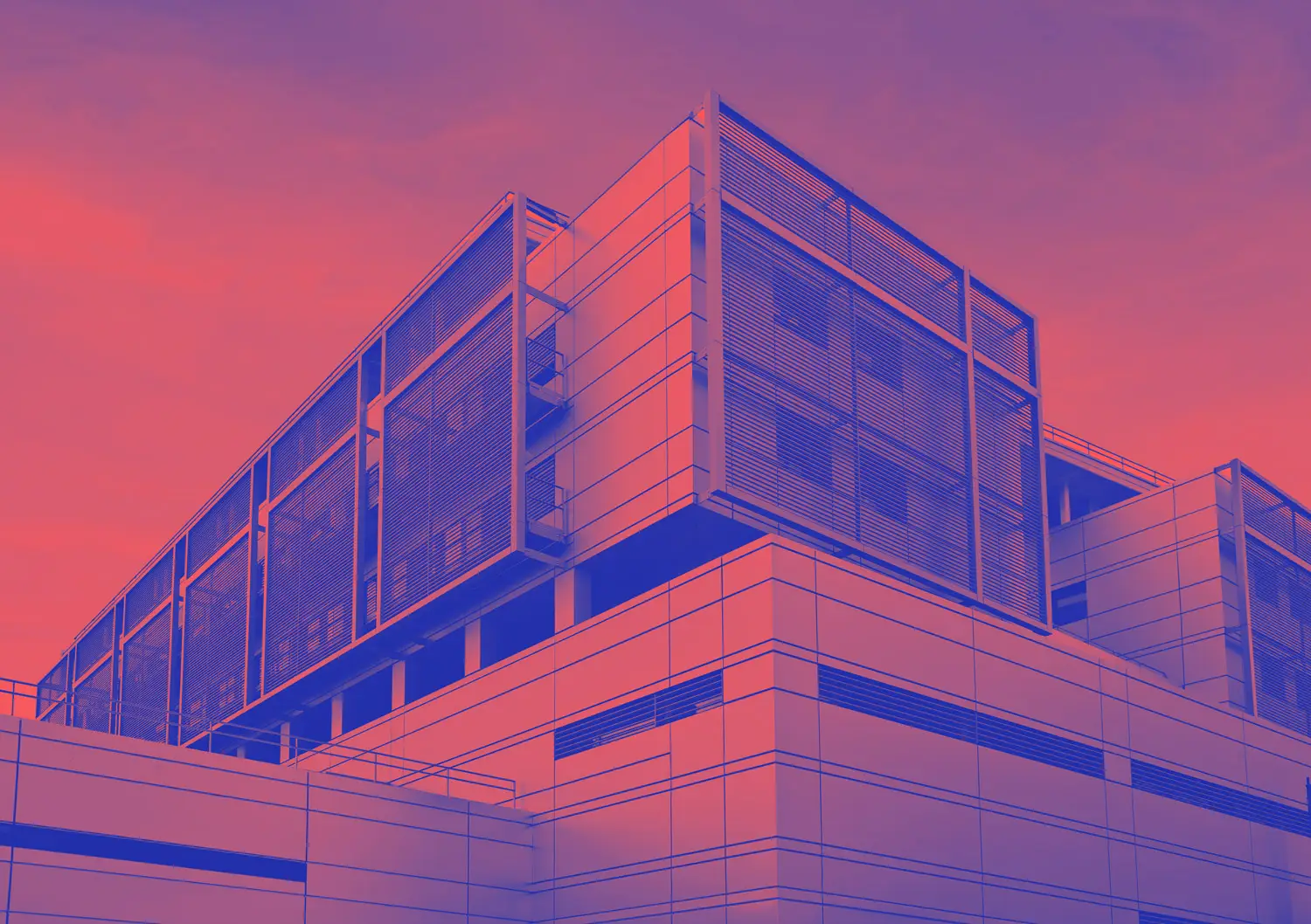 Modernes Bürogebäude mit Glasfassade und klarer Architektur unter bewölktem Himmel.