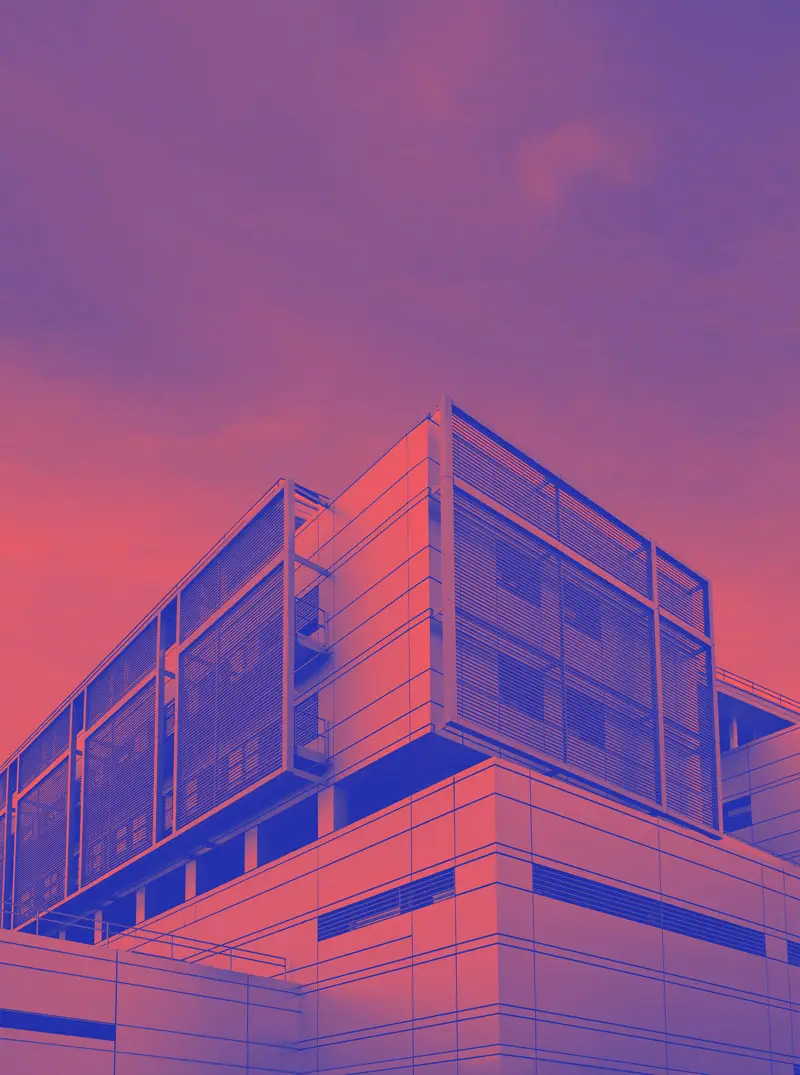 Modernes Bürogebäude mit Glasfassade und klarer Architektur unter bewölktem Himmel.